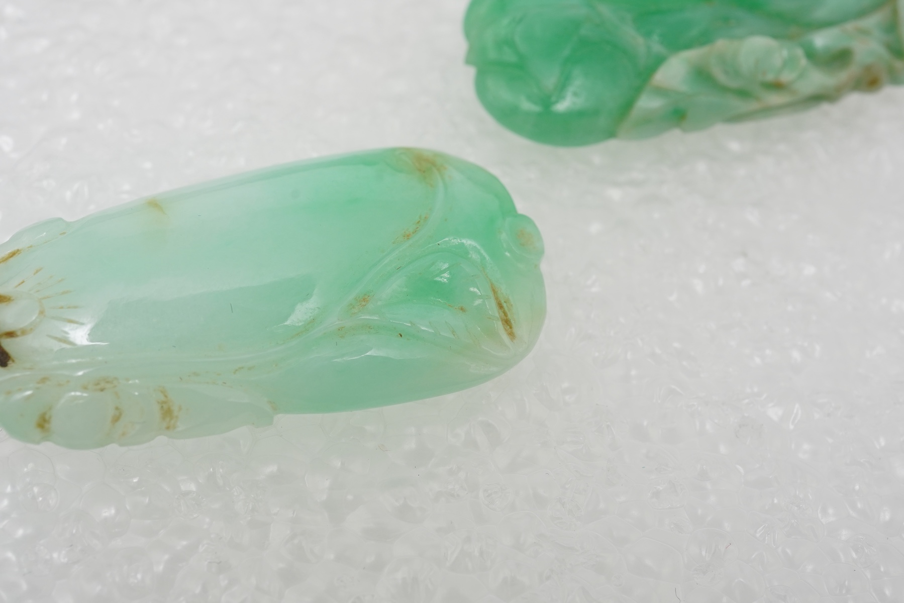 Two carved jadeite pendants, China, early 20th century, each carved to depict a fruiting vine of bitter gourd, longest 3.5cm excluding bail, combined gross weight approximately 10 grams